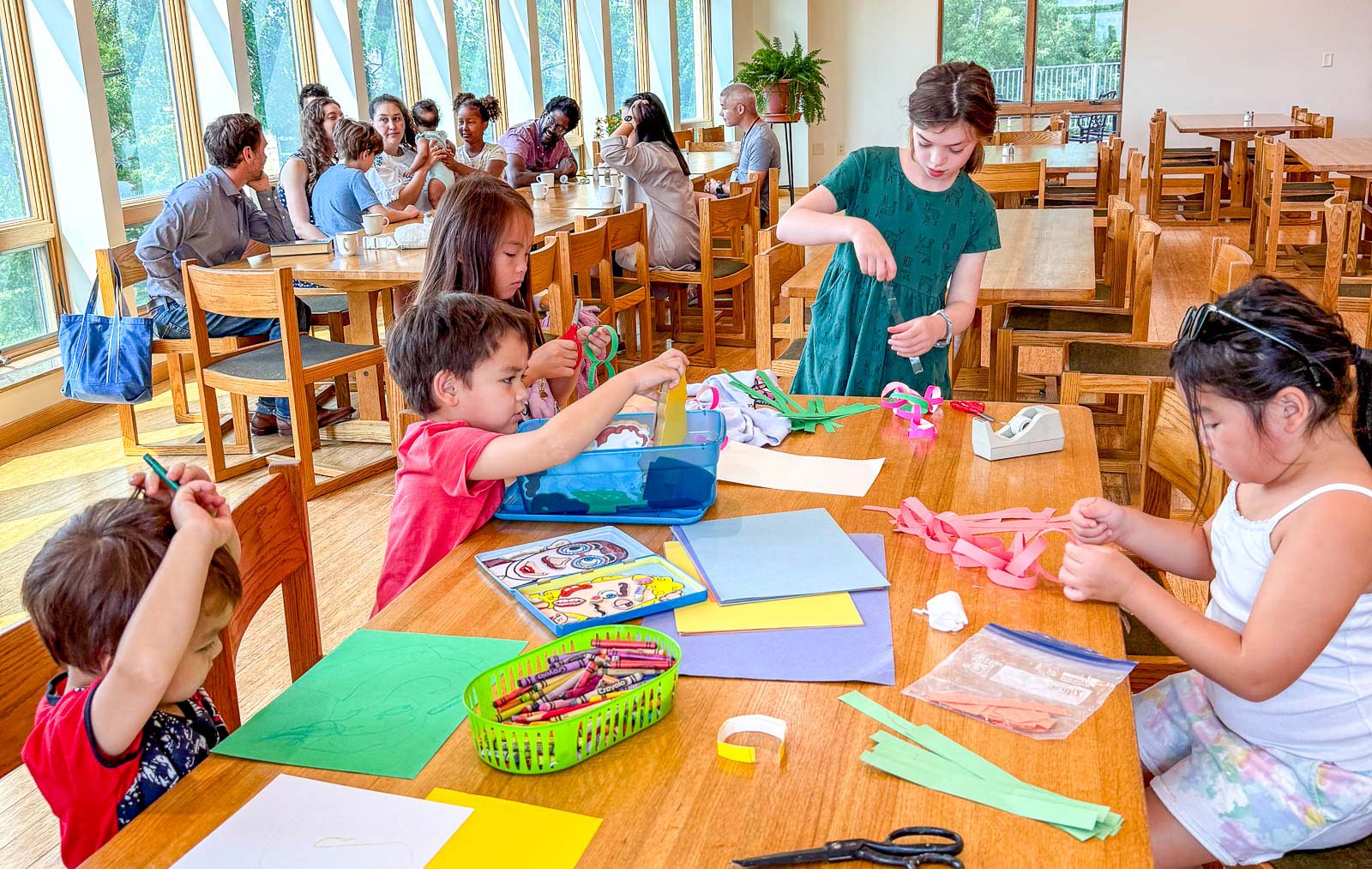 Family gathering around a table doing arts and crafts